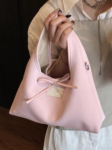 French minimalist pale pink dumpling handbag with bow accent and chain crossbody strap