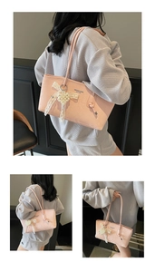 Detail of pink fashion tote bag with lace bow and pearl heart charm accessory