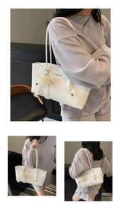 White faux leather shoulder bag with pearl heart charm and textured finish