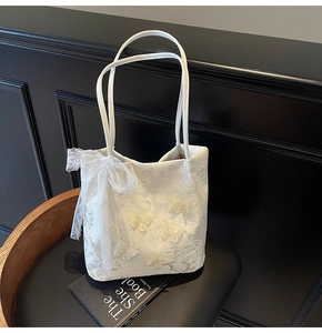Dettaglio della borsa tote in pizzo bianco con farfalle 3D e un grande fiocco in pizzo