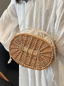 Handmade oval straw crossbody bag with white pearl strap and inner drawstring liner