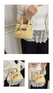 Detail view of lychee pattern leather bucket bag with silver lock and heart charm