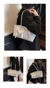 Detail view of silver snake-print tote bag featuring lace pearl pendant and slim handles