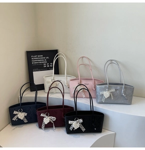 Detailed display of snakeskin patterned tote bags in six colors with pearl heart charms
