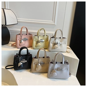 Detail of lychee pattern leather handbags in various colors with metallic heart charms