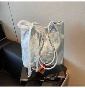 Vista dettagliata della borsa tote in jacquard azzurro con fiocco in pizzo e farfalle 3D