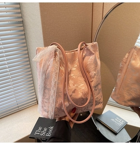 Dettaglio della borsa tote rosa con ricami floreali 3D e nastro in pizzo bianco