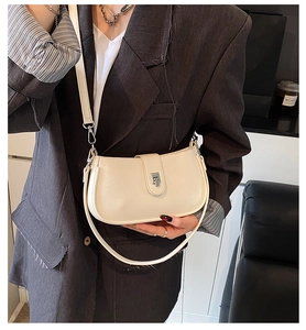 Detailed view of cream leather shoulder bag with polished silver hardware lock
