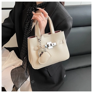 Detail view of lychee pattern leather bucket bag with silver lock and heart charm