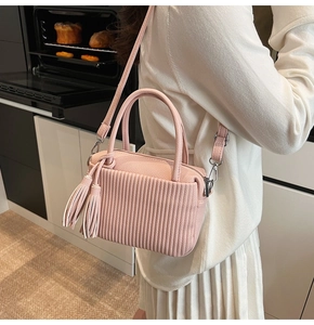 Détail du sac en cuir plissé rose avec pampilles et bandoulière réglable pour femmes