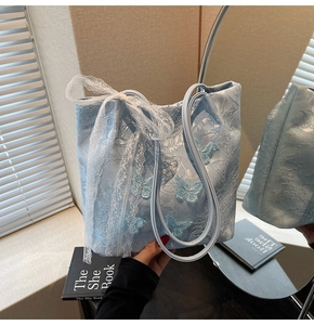Dettaglio della borsa tote azzurra con ricamo a farfalla 3D e grande fiocco in pizzo