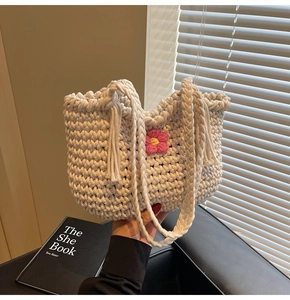 Detailed macro view of the coarse cotton rope weave and pink crochet flower on the tote bag