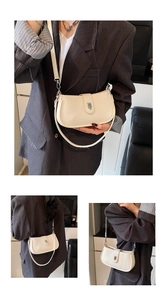 Detail view of cream oil wax leather underarm bag featuring a silver metal turn-lock closure