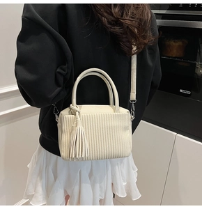 Vue détaillée du sac à main plissé crème avec pampille à franges porté par un mannequin