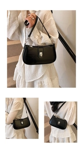 Detail view of glossy black leather shoulder bag showing silver buckle and strap texture