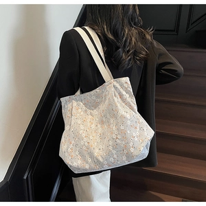 Detailaufnahme der großen geblümten Spitze-Tote-Bag mit Schultergurt in einem Lifestyle-Szenario