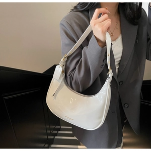 Detail of white patent leather hobo bag showing adjustable strap and golden hardware