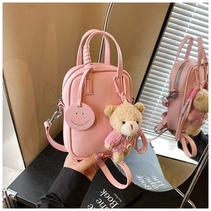 Pink lychee texture mini crossbody bag with a cute bear charm and a round smiley tag detail