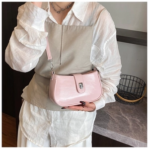 Detail of light pink patent leather shoulder bag with metallic buckle and glossy finish
