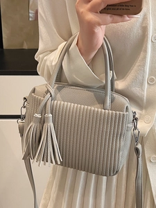 Petit sac à main gris clair en cuir avec design plissé et deux glands en cuir