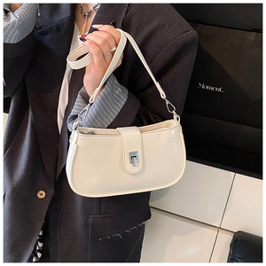 Detailed close-up of cream oil-wax leather texture and silver square buckle on shoulder bag