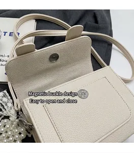 Vue détaillée du sac crème avec fermeture magnétique et texture cuir grainé