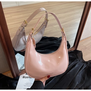 Detailed mirror view of pink glossy patent leather hobo bag with gold buckle detail