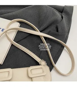 Détail de la boucle argentée réglable et de la bandoulière en cuir grainé du sac carré