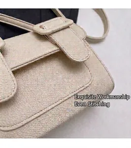 Gros plan sur le cuir grainé blanc crème et les coutures précises de ce sac rabat