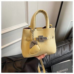Detail showing the light yellow lychee pattern leather texture and silver twist lock closure