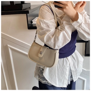 Close-up of minimalist cream underarm bag featuring a metallic silver rectangular clasp
