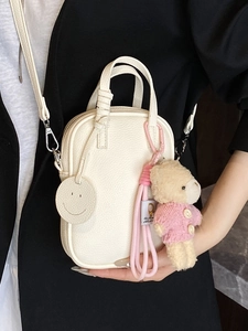 Minimalist white lychee leather mini crossbody bag with cute plush bear and smiley charm