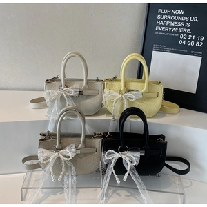 Detail view of four-color mini bucket bags with lace pearl bows on stylish display