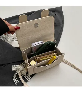 Vue intérieure du sac beige avec oreilles de lapin montrant le rangement des essentiels