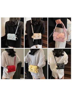 Différentes couleurs de sacs bandoulière portés par un mannequin dans un escalier