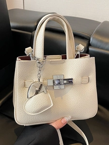 Beige lychee texture leather bucket bag with silver twist lock and heart pendant