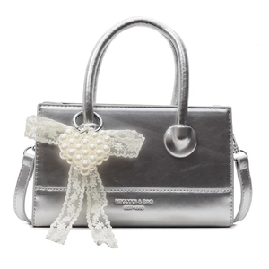 Silver metallic crossbody handbag with white lace bow and pearl heart charm accessory