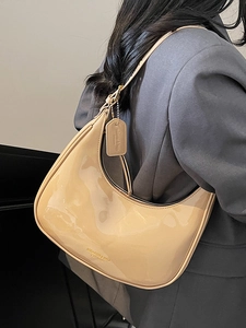 Chic beige patent leather half-moon shoulder bag with sleek minimalist underarm style