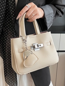 Chic beige lychee pattern leather bucket bag with silver twist lock and heart charm