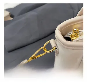 Détail du fermoir mousqueton doré de qualité et de la fermeture éclair du sac seau beige