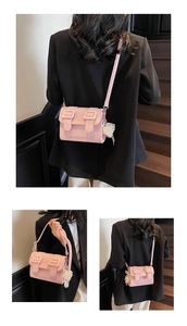 Pink satchel bag detail with lychee texture and pearl heart decorative charm accessory