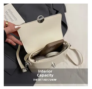 Detail of minimalist cream crossbody bag showing internal capacity for phone and makeup