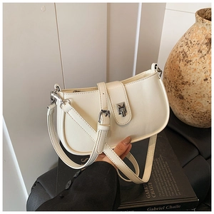 Macro shot of white oil wax leather shoulder bag with metallic clasp and adjustable strap