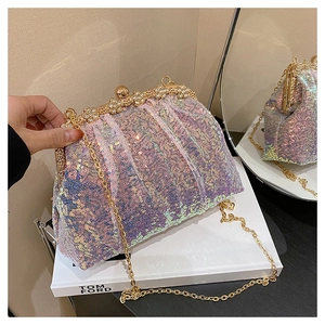 Vue détaillée des paillettes irisées et du fermoir diamant floral sur pochette de soirée
