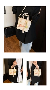 Détail du mini sac seau crème avec imprimé orange et breloque à pampille dorée élégante
