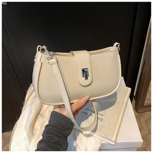 Close-up of cream white faux leather shoulder bag with silver metal twist lock and texture