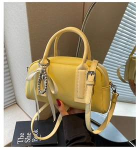 Detail of yellow lychee pattern Boston bag with silver bead and ribbon charm