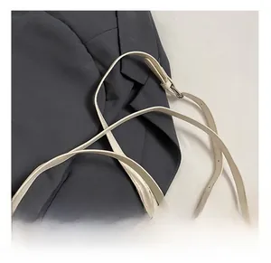 Detail of adjustable strap with bright metal buckle on a beige faux leather handbag