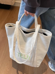Canvas tote bag with green TELN embroidery and dual handles for shoulder carry