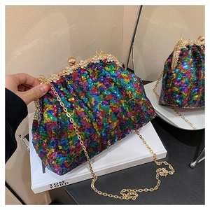 Gros plan détaillé sur les paillettes colorées et le fermoir floral doré de la pochette